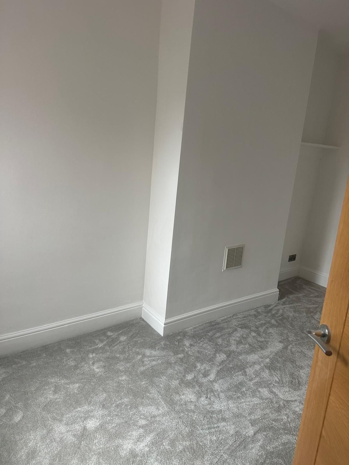 Finished bedroom with new grey carpet and white skirting
