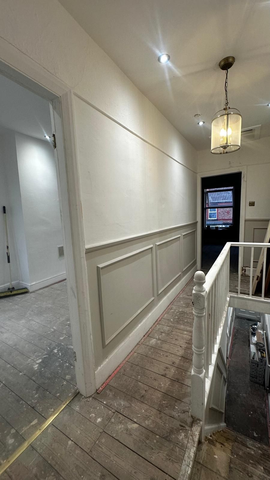 Landing with bare, paint-splashed floorboards