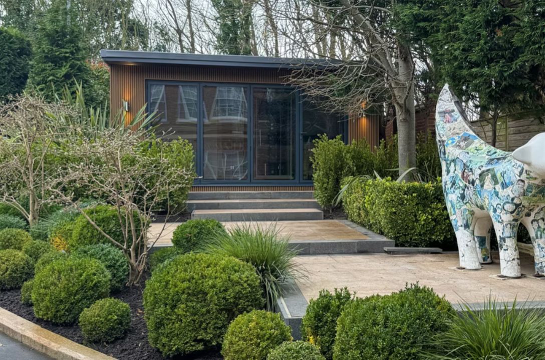 Garden studio set behind landscaped planting and paving