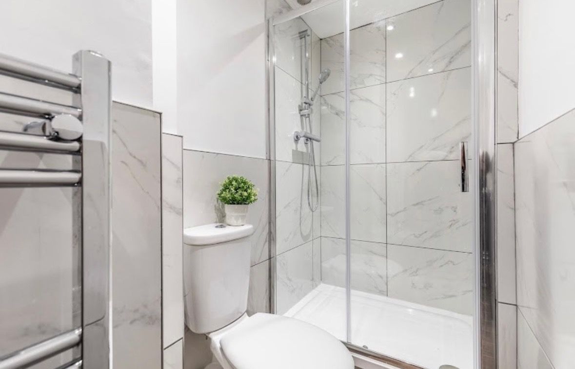 Modern shower room with glass enclosure and marble-effect tiles